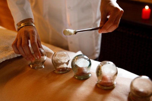 一位年轻女子在按摩院休息。用真空杯对妇女背部进行医学拔罐治疗，合上，中药图片下载