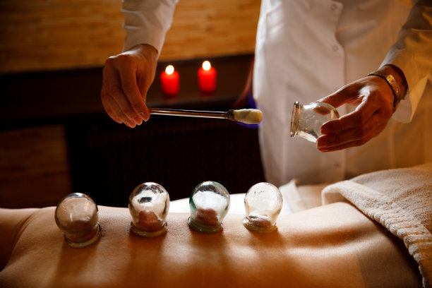 一位年轻女子在按摩院休息。用真空杯对妇女背部进行医学拔罐治疗，合上，中药图片下载