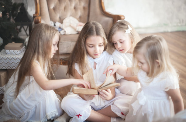 姐妹女孩们正在孩子们的房间里看书。圣诞节和寒假。高质量的照片图片下载