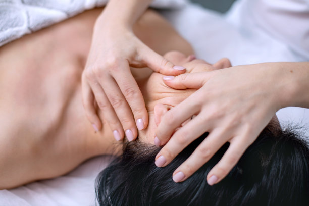 为年轻女性按摩脸部和头部。面部和身体皮肤的美容程序。替代医学。成年期皮肤护理。人的水平照片图片下载