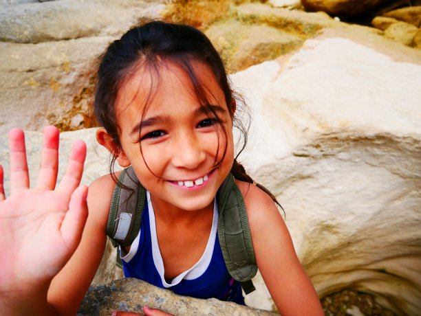 在白色岩石间微笑的小女孩图片下载