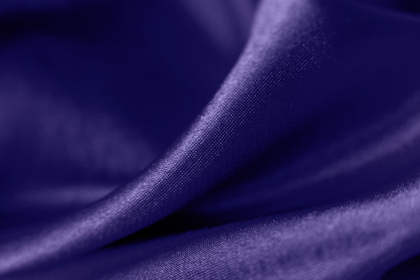 时髦的颜色非常接近光滑的丝绸背景。关闭了。优雅明亮的缎子波浪。织物背景，从上面看。奢华的紫布质感。图片下载