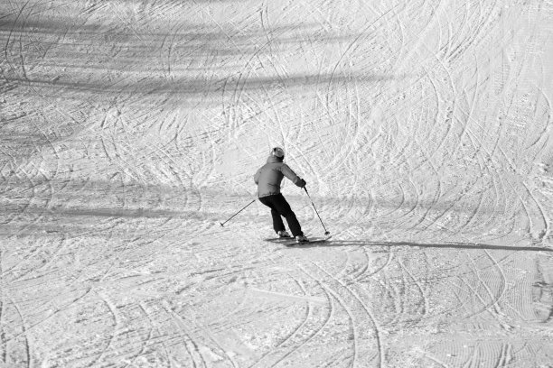 滑雪者在雪上滑雪坡下降。黑色和白色。高对比度。图片下载