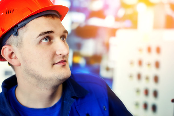 燃气锅炉房操作员检查设备压力。工程师戴着头盔工作的照片。真实的现场工作流程。锅炉房的工人。模糊的背景。气化和能源图片下载