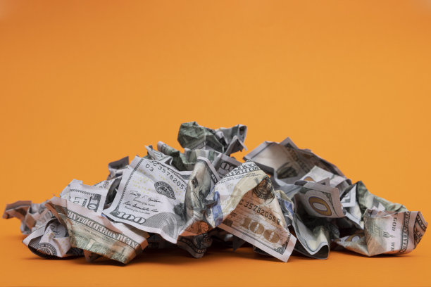 橙色背景上掉落的褶皱100美元纸币图片下载