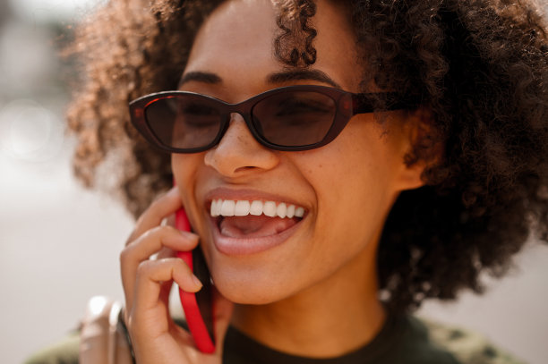 一个微笑的可爱的女人在电话里说话的特写照片图片下载