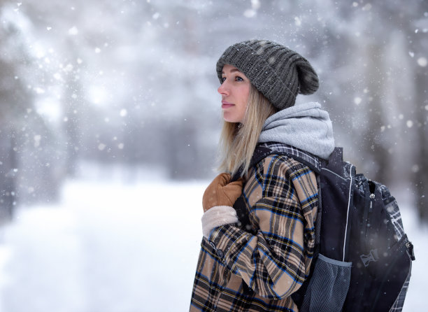 一名年轻女子穿越了一片冬季森林图片下载