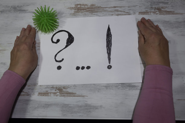 女性的手放在一张写着问号的纸旁边图片下载