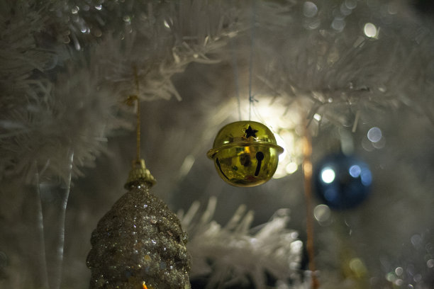 圣诞装饰金色的铃铛在白色圣诞树的背景上图片下载