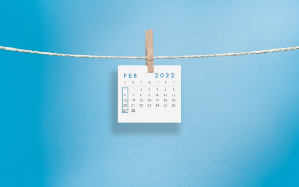 白色的2022年2月日历页挂在蓝色背景的晾衣绳上图片下载