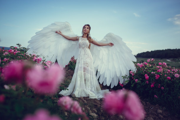 美丽的女人在花卉公园，花园里的玫瑰。化妆，头发，玫瑰花环。图片下载