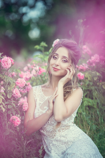 美丽的女人在花卉公园，花园里的玫瑰。化妆，头发，玫瑰花环。图片下载