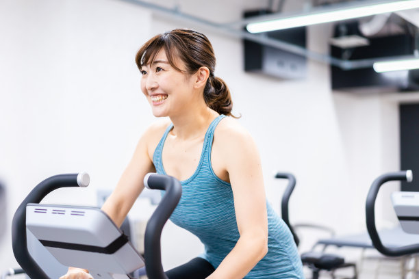 一个年轻女子在健身房里做机械训练图片下载