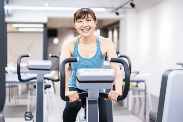 一个年轻女子在健身房里做机械训练图片下载