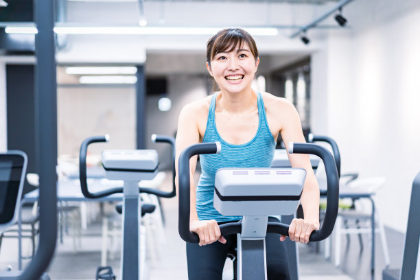 一个年轻女子在健身房里做机械训练图片下载