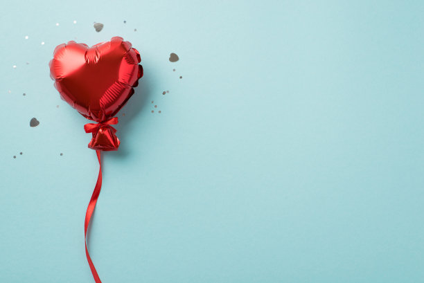 俯视图照片的情人节装饰红色心形气球与彩带亮片和五彩纸屑在孤立的粉彩蓝色背景与空空间图片下载