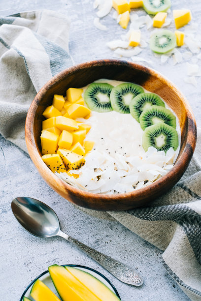 健康水果冰沙碗芒果，椰子片和猕猴桃。图片下载
