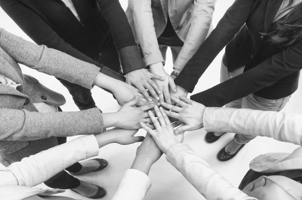 一群人把手合在一起挤作一团。图片下载