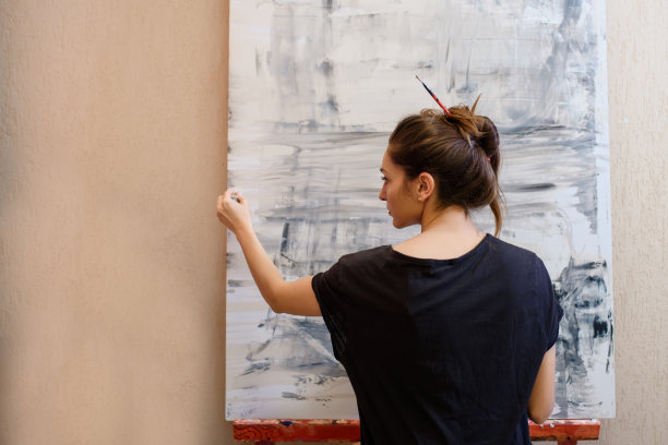 一位女画家在她的画室里用她的画笔画了一幅抽象画图片下载
