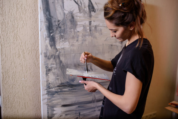 性感的女人画家在她的艺术工作室画一幅抽象的画图片下载