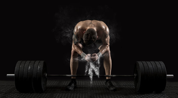 肌肉男在健身房用杠铃锻炼。运动横幅图片下载