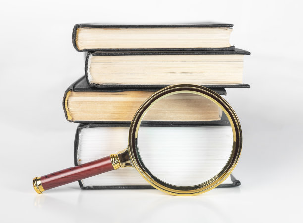 放大镜和书堆。知识概念，学术研究和学习。放大镜和教科书图片下载
