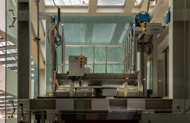 电梯发动机玻璃房配电梯电机。电机驱动电梯电缆控制室。钢丝绳控制电梯。图片下载