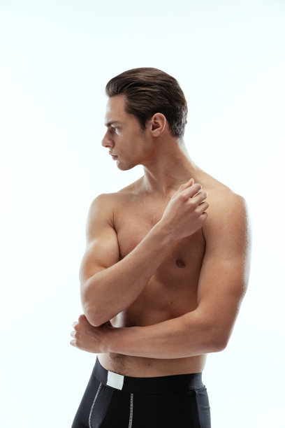 半身像年轻英俊的运动男子赤膊穿着黑色四角内裤站在白色背景孤立。图片下载