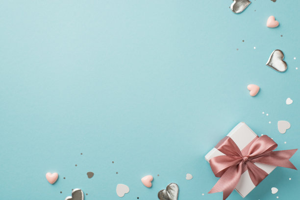 情人节装饰的俯视图照片白色礼品盒与粉红色蝴蝶结、银色和粉红色的心形纸屑和亮片在孤立的淡蓝色背景与空白空间图片下载