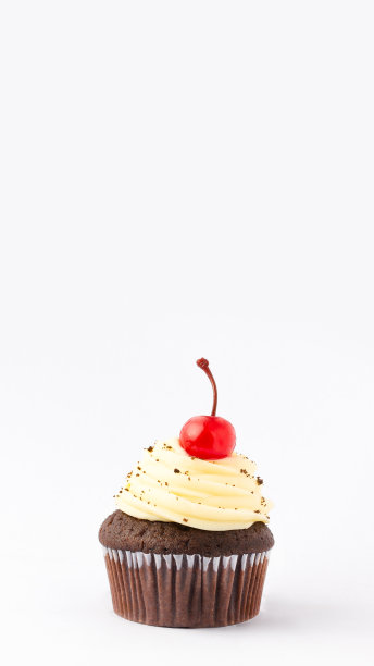 松饼，上面有一颗樱桃，孤立在白色的背景上。带有复制空间的垂直横幅。图片下载