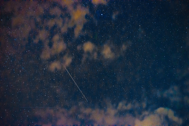 夜晚的图片，蓝色的空间和明亮的星星与云和一个移动的星星产生了一条直线图片下载