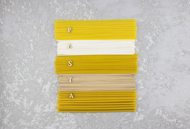 俯视图的长意大利面和意大利面铺设在一起与木制字母的单词-意大利面。平的。图片下载