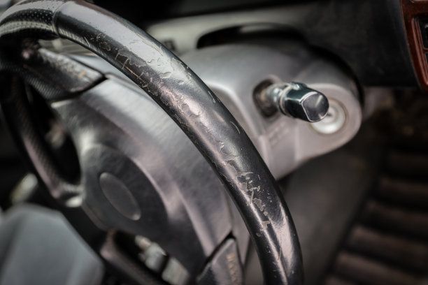 破旧的汽车黑色皮革方向盘的旧汽车特写图片下载