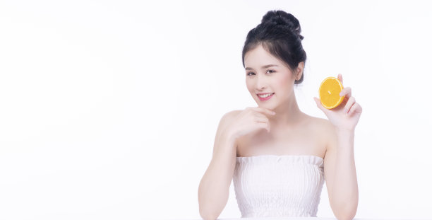 快乐的亚洲妇女持有新鲜的橙子片维生素c为好皮肤看着相机在孤立的白色背景。保健肤色活力或饮食生活方式的理念。图片下载