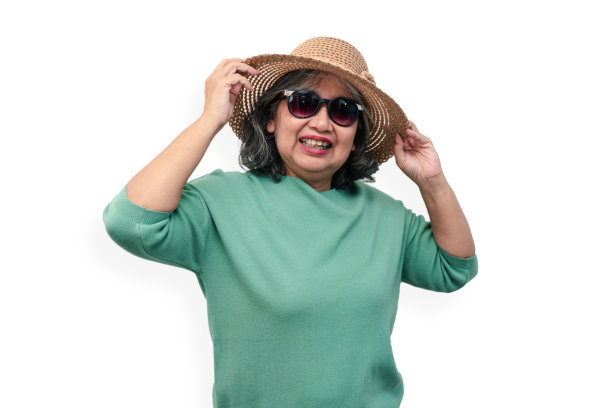 快乐的亚洲年长妇女的肖像戴太阳镜和一顶帽子站在孤立的白色背景。退休后的情人节旅游享受和乐趣的概念，退休后的生活方式图片下载