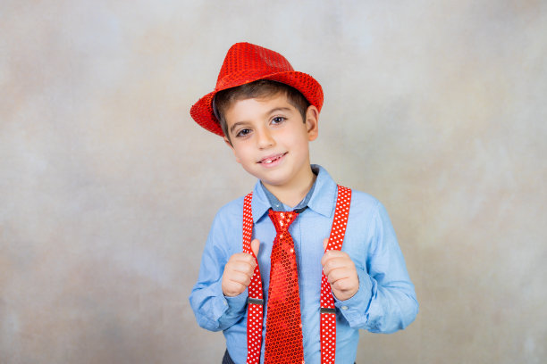 狂欢节上戴着帽子、背带和领带的滑稽男孩图片下载