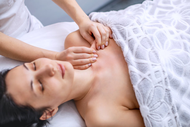 年轻女子的身体按摩。用芳香油替代健康方法。面部和身体皮肤的美容程序。成年期皮肤护理。人的水平照片图片下载
