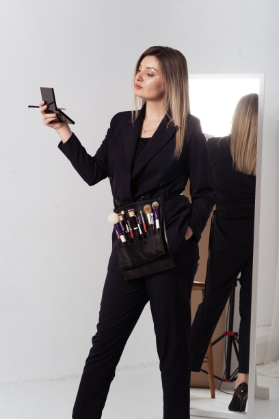 女设计师与调色板化妆品和化妆刷。白色工作室背景。图片下载