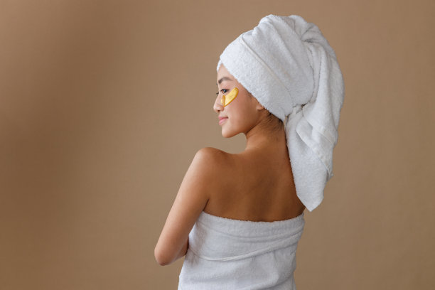 年轻的女人带着金色眼罩站在演播室里图片下载