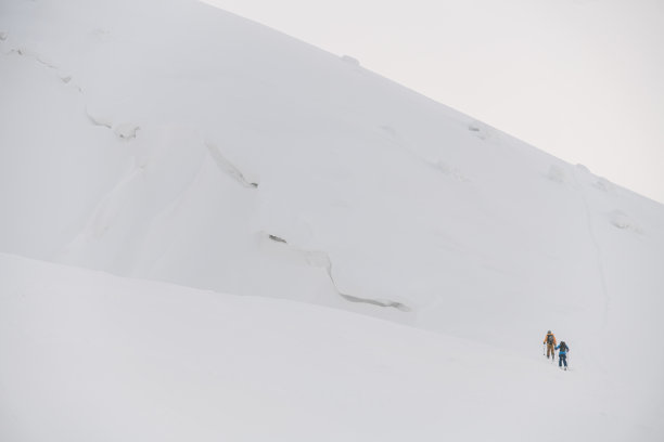 令人惊叹的白雪皑皑的山坡，自由骑手沿着它攀登图片下载