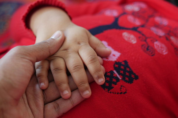 父亲牵着孩子的手，靠近。图片下载