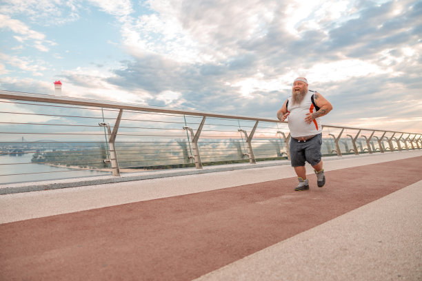 留着胡子的白种胖男人，满身刺青，正在做早操减肥图片下载