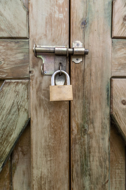 一扇用挂锁封闭的旧木门的纹理细节，以上锁入口和安全的概念为背景图片下载