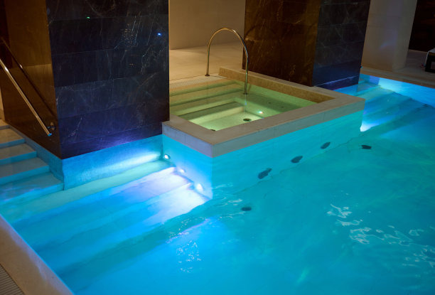 在健康水疗度假村的豪华休息区，您可以欣赏到美丽宽敞的室内热水池和美丽的水下照明图片下载