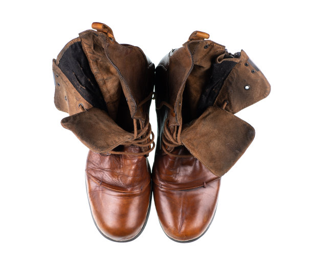 旧旧的棕色皮靴与鞋带在白色的背景图片下载