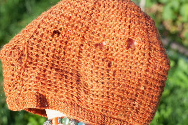 针织妇女的橙色帽子与洞图片下载