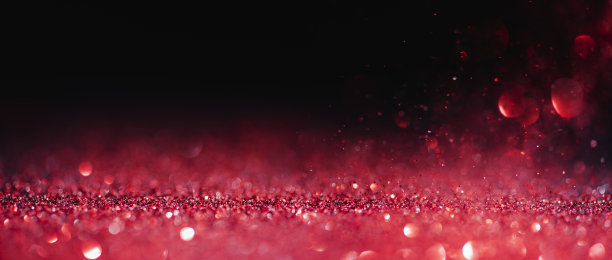 抽象模糊红色闪光在黑色背景。情人节贺卡，圣诞节贺卡和婚礼贺卡。爱散景闪耀五彩纸屑纹理布局。图片下载