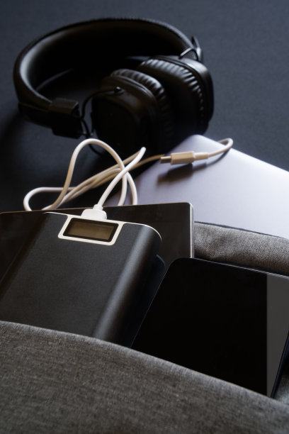 现代USB设备:智能手机、笔记本电脑和平板电脑，连同外接电池和耳机放在一个灰色的背包或包里。在旅行和旅行中为USB设备充电的概念图片下载