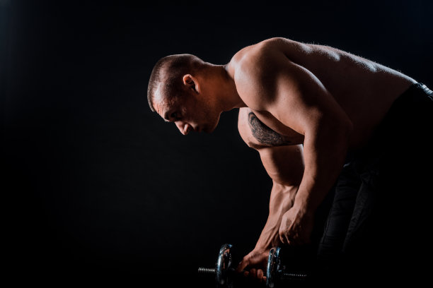 一个身材健美的男人手里拿着哑铃图片下载