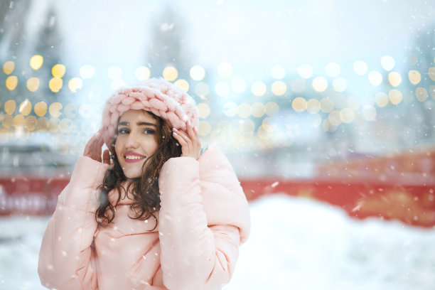 迷人的女士在冬季集市上散步，背景是花环图片下载